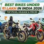 A promotional banner for "abtadka" featuring a lineup of four modern commuter motorcycles on a highway. The central text reads "BEST BIKES UNDER ₹1 LAKH IN INDIA 2026 | TOP PICKS, MILEAGE & PRICES." The image includes the abtadka logo, fuel pump icons, and rupee symbols, all set against a bright, scenic outdoor background.