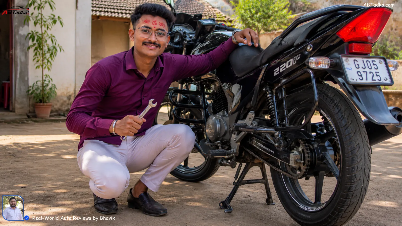 Bhavik Munjapara smiling next to his well-maintained bike, holding a spanner