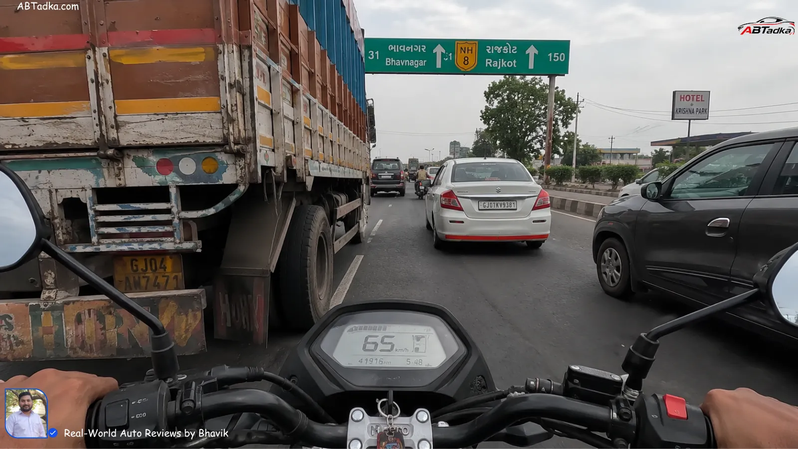 View from rider perspective on Gujarat NH-8 showing a 100cc bike struggling to overtake a truck at 65 km/h with heavy traffic, clicked during Bhavik's Ahmedabad-Bhavnagar test ride