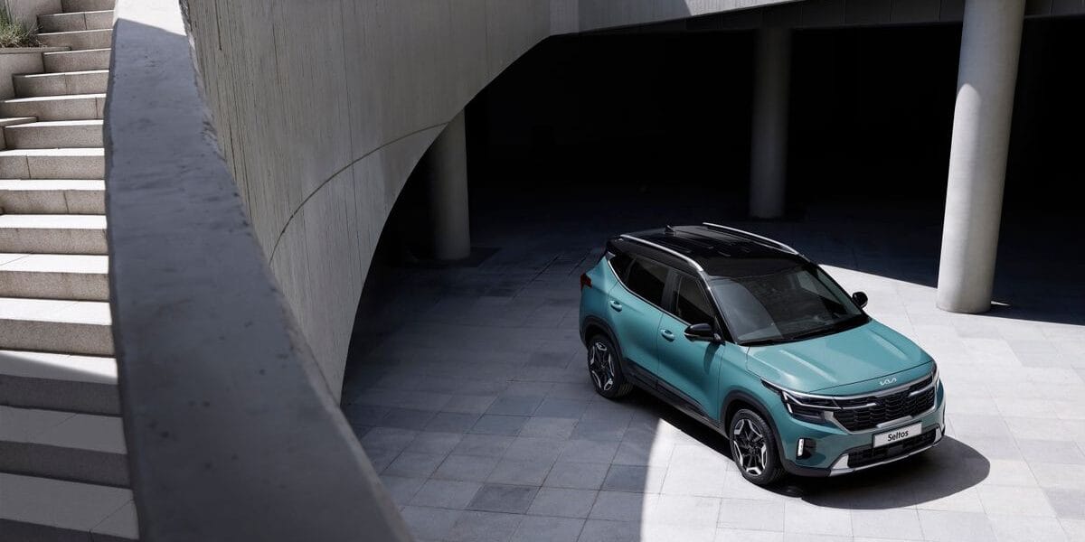 Green SUV parked in a modern architectural setting with concrete walls and stairs.