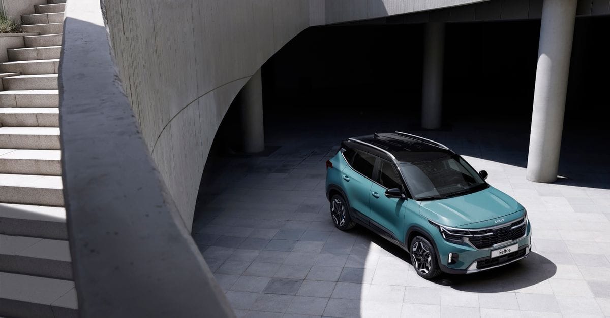 Green SUV parked in a modern architectural setting with concrete walls and stairs.